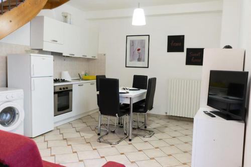 托爾托納的住宿－[Appartamento Duomo]，厨房配有桌椅和电视。