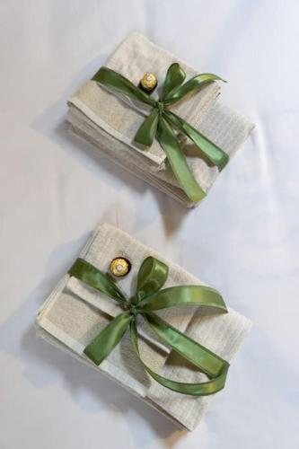 dos regalos envueltos con arcos verdes en una mesa blanca en [Appartamento Duomo] en Tortona