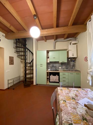 a kitchen with green cabinets and a table in a room at L'orologio matto in Marina di Carrara