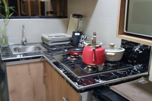 uma cozinha com um fogão com panelas e frigideiras em DEPARTAMENTO A UNA CUADRA DE LA PLAZA DE ARMAS TRUJILLO em Trujillo