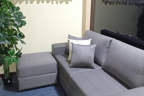 um sofá cinzento com almofadas numa sala de estar em DEPARTAMENTO A UNA CUADRA DE LA PLAZA DE ARMAS TRUJILLO em Trujillo