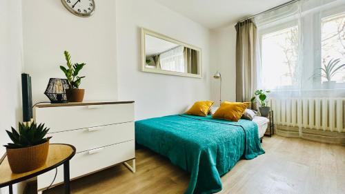 a bedroom with a bed and a table and a clock at Cosy Stay Muranów in Warsaw