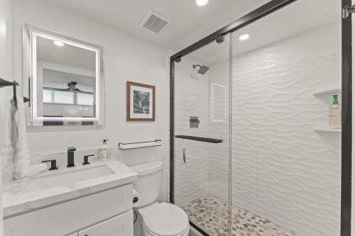 Un baño con ducha, inodoro y lavabo. en Fully Remodeled Ocean Front Comfort HKOK316, en Kihei