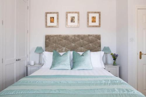 a bedroom with a large bed with blue pillows at Central Chichester 3bd Mews House For Up To 6 in Chichester