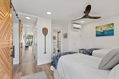 Un dormitorio con dos camas y un ventilador de techo. en Fully Remodeled Ocean Front Comfort HKOK316, en Kihei