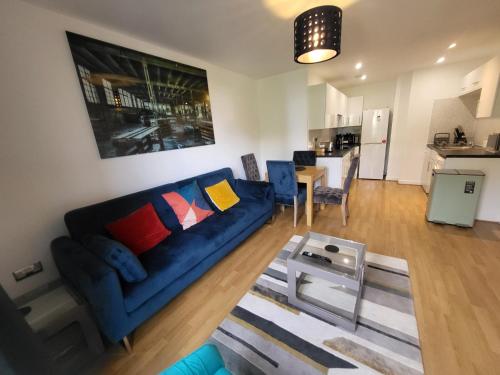 a living room with a blue couch and a table at Garland Central City Apartment London 2 in London