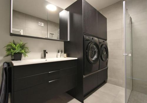 łazienka z umywalką i pralką w obiekcie Beautiful apartment in Akureyri w Akureyri