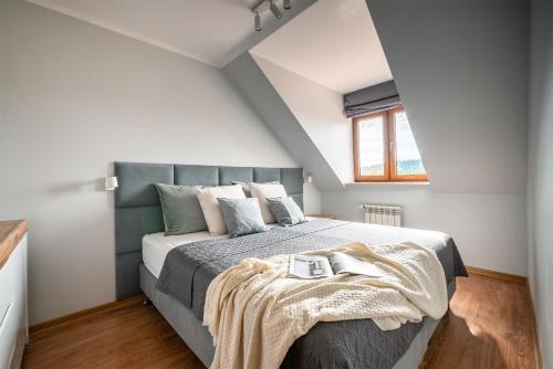 une chambre avec un grand lit dans un grenier dans l'établissement Dom nad jeziorem Morenowe Wzgórze, à Płociczno