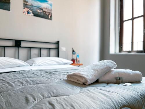 a bed with two white towels on top of it at Ostello Bello Napoli in Naples