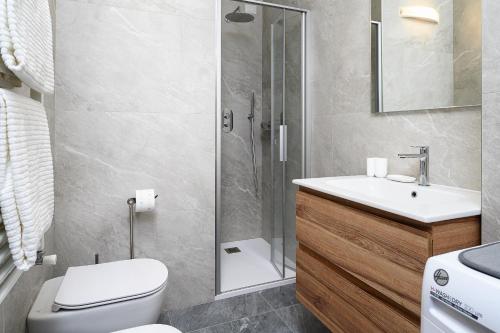 un bagno con doccia, WC e lavandino di A Casa dell'Orso a Bormio