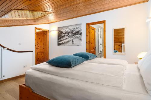 a bedroom with a large bed with blue pillows on it at A Casa dell'Orso in Bormio