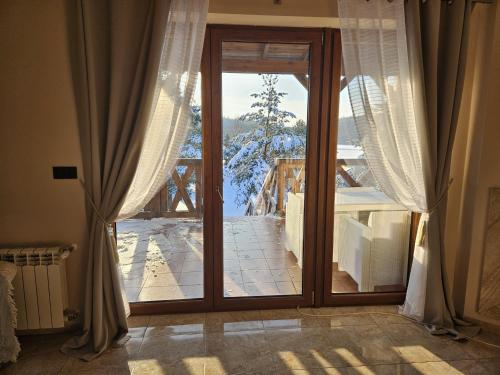 d'une grande porte en verre avec vue sur un balcon. dans l'établissement Dom nad jeziorem Morenowe Wzgórze, à Płociczno