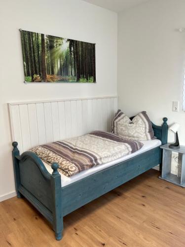 a bed in a room with a picture on the wall at Gemütliches Eifeler Gästehäuschen in Nettersheim