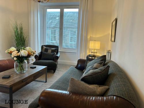 a living room with a couch and a coffee table at Annie’s Flat in Aberfeldy