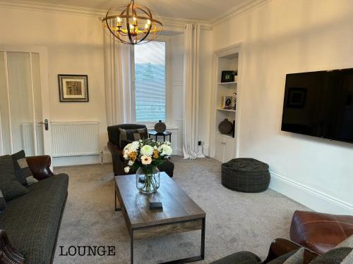 a living room with a vase of flowers on a coffee table at Annie’s Flat in Aberfeldy
