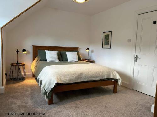 a bedroom with a bed and two lamps and a staircase at Annie’s Flat in Aberfeldy