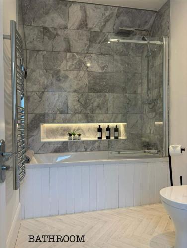 a bathroom with a tub and a sink at Annie’s Flat in Aberfeldy