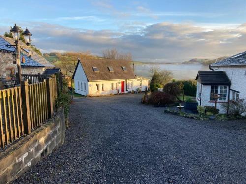 a small village with houses and a fence at Barn Owl Cottage, The Welsh Reindeer Retreat, Ystradfach Farm , Llandyfaelog, Carmarthen , SA17 5NY in Carmarthen