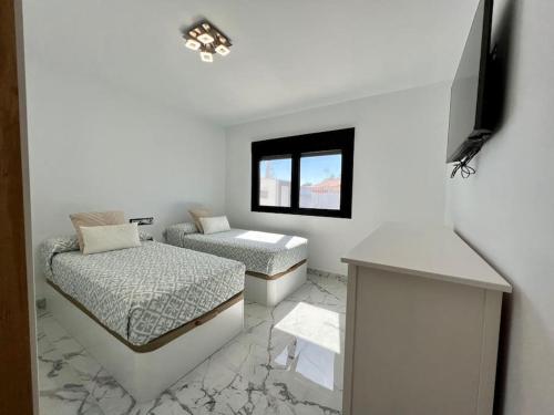 biały pokój z 2 łóżkami i oknem w obiekcie Luxury bungalow Holycan w mieście San Bartolomé