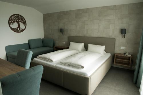 um quarto com uma cama, um sofá e uma mesa em Pension Strobl em Mondsee