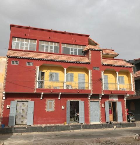 a red and yellow building with a balcony at THURIN IMO in Saint-Louis