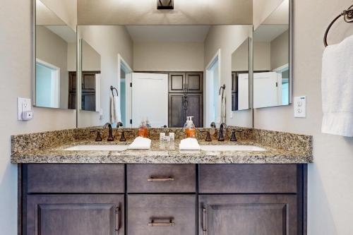 a bathroom with two sinks and two mirrors at Desert Jewel in Scottsdale