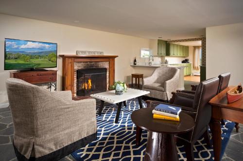 a living room with a fireplace with chairs and a table at The Equinox Golf Resort & Spa in Manchester