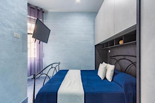 - une chambre avec un lit bleu et blanc et une télévision dans l'établissement Appartamento Stella Marina 3 - MyHo Casa, à San Benedetto del Tronto