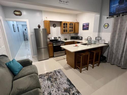 a kitchen with a stainless steel refrigerator and a couch at Sunrise Manor 2-Bedroom APT#2 in Cherryfield