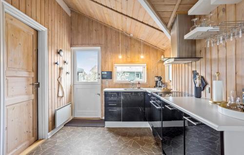 a kitchen with wood paneling and a sink and a counter at Amazing Home In Frørup With Wi-Fi in Frørup