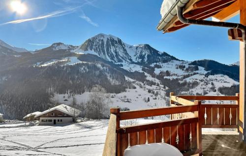 - une vue sur une montagne enneigée depuis une terrasse couverte dans l'établissement Les Neisieux, à Manigod
