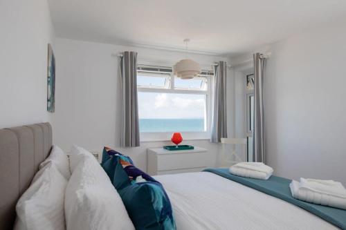 a bedroom with a bed and a window with the ocean at High-End Beachfront Getaway Sea View King Bed in East Wittering