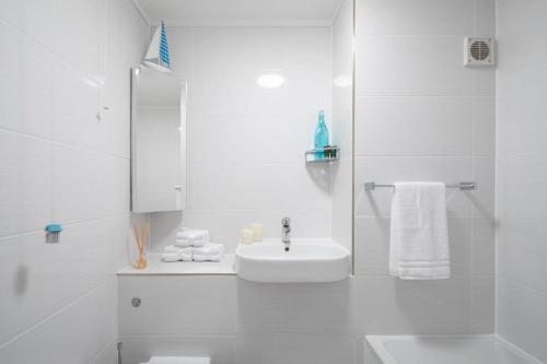 a white bathroom with a sink and a shower at High-End Beachfront Getaway Sea View King Bed in East Wittering