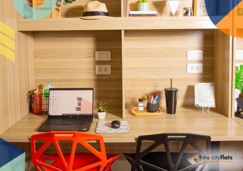 a desk with a laptop and a red stool at The City Flats Amorsolo in Manila