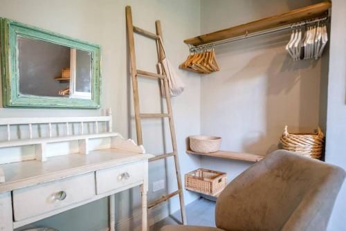 een ladder en een stoel in een kamer met een spiegel bij Dove Point, Orford in Woodbridge
