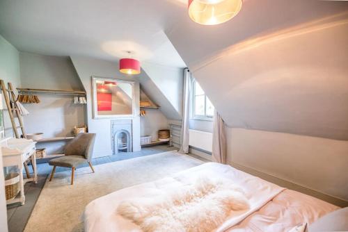 een slaapkamer op zolder met een bed en een stoel bij Dove Point, Orford in Woodbridge