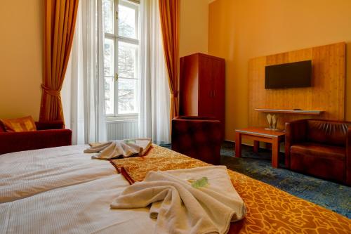 a hotel room with a bed and a window at Zámek Křtiny in Křtiny