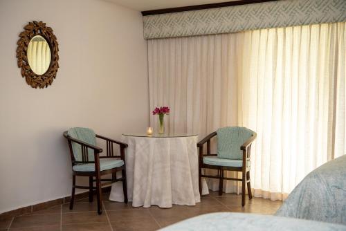 a room with a table and two chairs and a mirror at Hotel Panamonte in Boquete