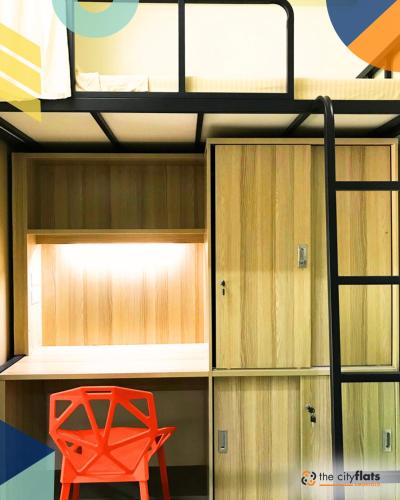 a bunk bed with a red chair in a room at The City Flats Amorsolo in Manila