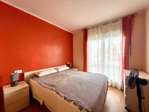 1 dormitorio con paredes de color naranja, 1 cama y ventana en AQUAMARINA011, en Roses