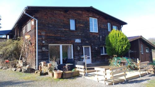 a log cabin with a porch and benches in front of it at Gite Les Melezes in Dabo