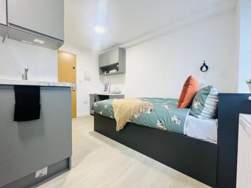 1 dormitorio con 1 cama y cocina con fregadero en Contemporary Chic Studio in Stretford en Mánchester