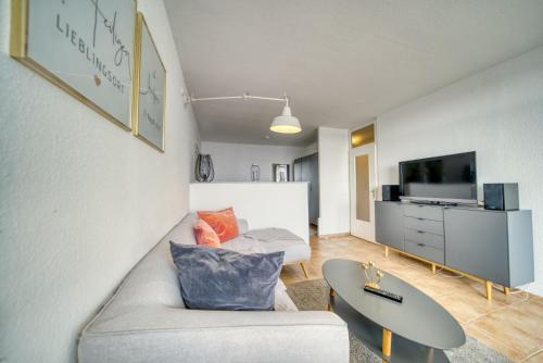 a living room with a couch and a tv at Ferienpark - Haus E, App 0E0903 in Heiligenhafen