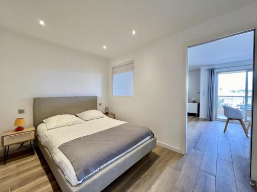 a bedroom with a large bed and a large window at Beau 2 pièces proche mer - piscine et clim in Vallauris