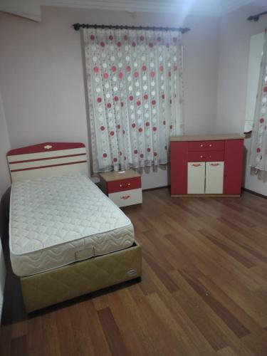 a bedroom with a bed and a curtain and wooden floors at ERCİYESİN MÜKEMEL MANZARASI in Kayseri