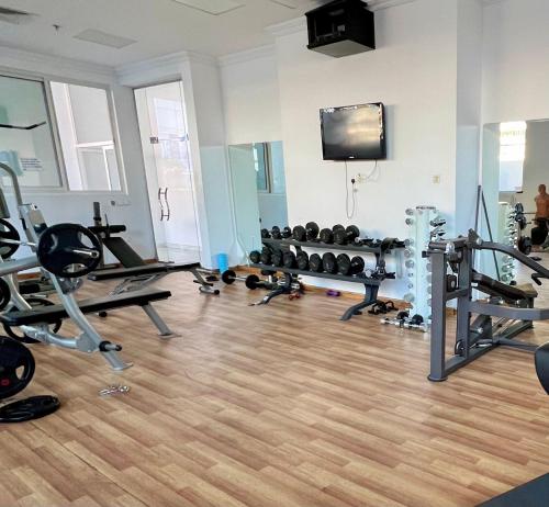 a gym with several tread machines and a flat screen tv at Silicon Path Spacious studio in Dubai