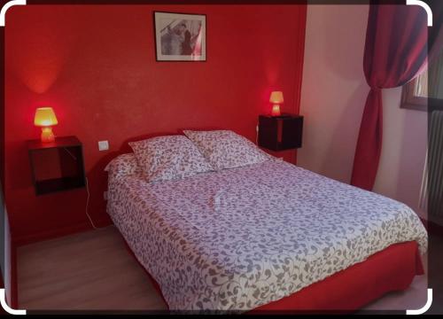 a bedroom with a bed with red walls and two lamps at HOTEL LAC PAVIN in Besse-et-Saint-Anastaise