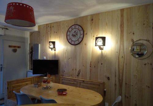 a dining room with a table and a clock on the wall at Appartement Saint Lary in Vielle-Aure