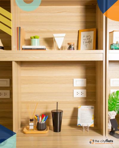 a wooden shelf with pens and pencils on it at The City Flats Amorsolo in Manila