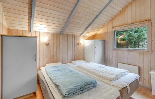 Oksbølにある3 Bedroom Cozy Home In Oksblの木製の部屋にベッド1台が備わるベッドルーム1室があります。